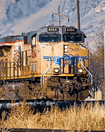 Running in an unusual 1x2 configuration, UP’s CLBWE9 can be seen snaking through the crossovers as they transition to Main 1. After the head end thunders by, we can hear the crew tone up Dispatch to receive instructions, as a defect detector at Milepost 696.9 has alerted the crew that it could not provide a reliable inspection of the train. Springville, UT 01/12/2026 14:48 MST —Locomotive Information—UP 8264 - GE ES44AC-H UP 7208 - GE AC44CW UP 8578 - EMD SD70ACe [Thundercab] #freighttrain #Unio