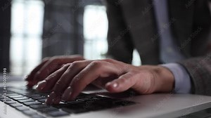 Hands of a man typing fast on a computer keyboard