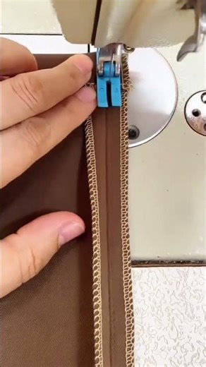 sewing brown fabric with industrial machine and finishing neat overcast edges for textile project