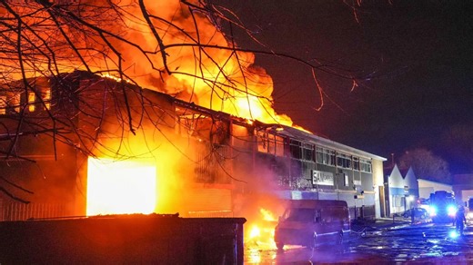 Moment two warehouses burn in huge blaze as 75 firefighters battle inferno