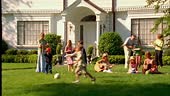 Adults and children play in a front yard on a beautiful summer day.