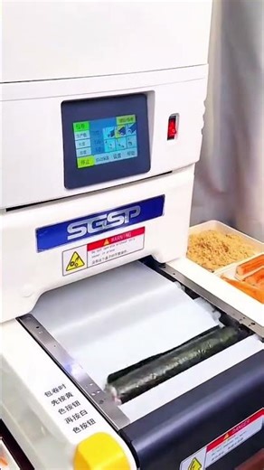 Automated sushi machine layering rice on seaweed
