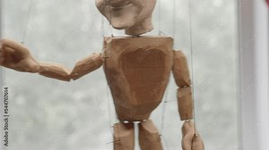 Handmade puppet doll on the strings close up with selective focus.