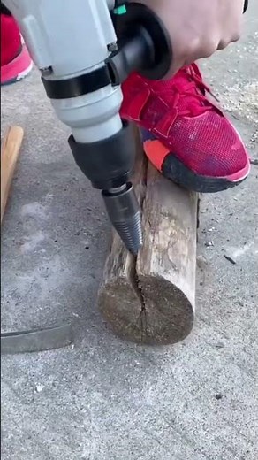 The process of splitting a log using an electric drill