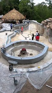 During construction and after construction. This backyard features a giant walk-through grotto, koi pond, waterfalls, outdoor kitchen, tiki hut, raised spa, a sun shelf, swim-up bar, and a tree house! Visit lucaslagoons.com to see more of this project. #insanepools #lucaslagoons #pool #poolbuilders #backyard #luxurylife #tikihut | Lucas Lagoons