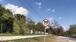 traffic sign for 30 kilometer per hour speed limit, 30 km speed limit sign. , Road sign board with speed limit 30 LTV written on it with trees in background
