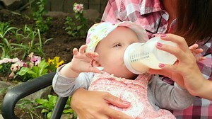 Baby girl drinking milk from a baby bottle - Free Stock Video