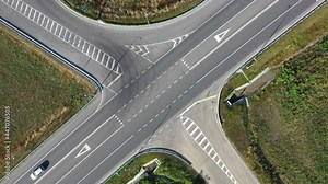 Aerial high drone in 4K flight over evening road traffic in Kiev, Ukraine. Highway and overpass with cars and trucks, interchange, two-level road junction in the big city. Top view.