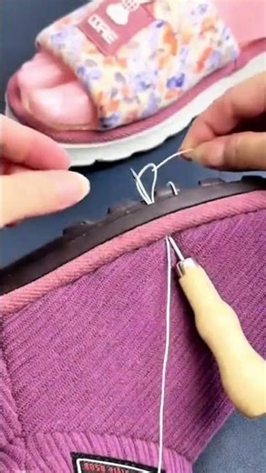 Sewing a purple fabric shoe sole manually using a long metal needle and a strong white cotton thread