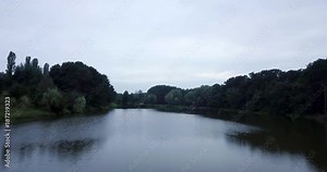 Flying over a evening river. Beautiful river after sunset. The forest is reflected in the water of the river. Beautiful evening sky. Aerial.