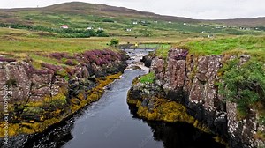 Scenic aerial view of the landscape in Scotland. Green grass, the river under the bridge, Scottish highlights in Isle of Skye.