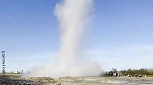Powerful Icelandic Strokkur Geyser erupting from a hole releasing steam