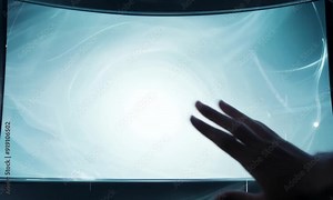 Interactive Future: Hand reaching out to a futuristic, curved holographic display, showcasing cutting-edge technology and innovation.