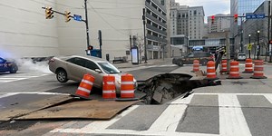 Car nearly falls into massive sinkhole