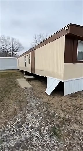 used mobile home listed at $12,400 From the outside, the home shows age, but the structure sits straight and level, with only one skirting panel needing attention. Inside, the flooring feels firm and the layout feels wider than expected for this budget. The living area offers enough space for daily use, while the kitchen includes older cabinets that still function properly along with working plumbing. The bedroom is positioned at the back and provides clean walls and solid flooring. The bathroom