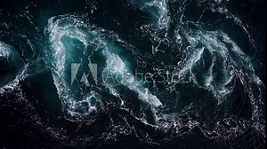 4K drone video with birds-eye view of the abstract and powerful water currents, rapids and whirlpools of the worlds larges maelstrom Saltstraumen, Norway.