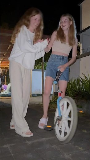 Girls learn to ride a unicycle.