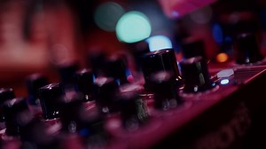 Sound engineer mixing music on analog mixing desk