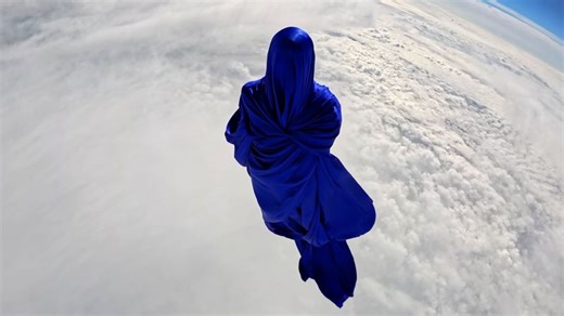 A silk figure floats at the edge of space