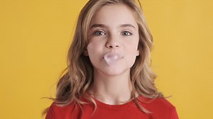 Free stock video - Teenage caucasian girl chewing gum and blowing bubble.