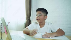 Asian boy student online learning class study online with laptop at home.