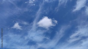 Diffused and sharp-looking cirrus clouds move across the blue sky along with the other clouds
