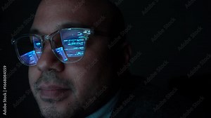 Close-up Reflection green code in lenses of glasses and eye of Male programmer works late at night, focusing on software development, coding, and cybersecurity analysis in dark room.
