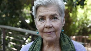 Older woman looks into camera with serious stare.