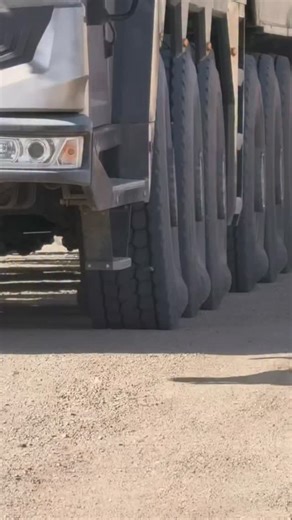 techy Universe | A line of heavy-duty trucks parked side by side, captured from a low angle near the wheels. The long rubber mud flaps hanging behind each... | Instagram