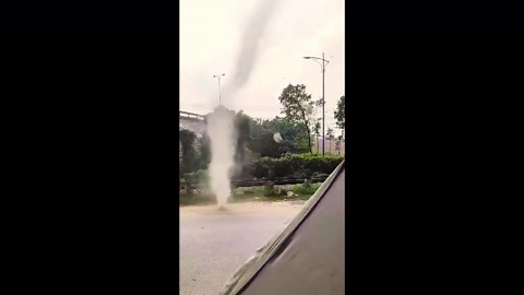 Dust devil tornado rips through road in Vietnam