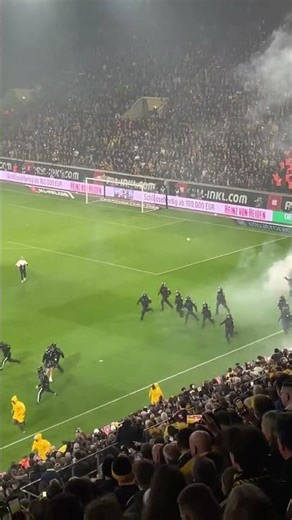 Dynamo Dresden fans run onto pitch and throw pyro at the Hertha BSC fans