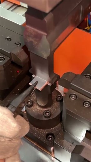 the process of pressing a multi-dot image shape onto a small, square flat iron using a special tool.