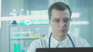 Doctor in the lab looking at the computer screen - Free Stock Video