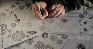 Hands of the artist designer draw symbols