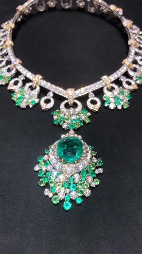 This high-jewellery emerald necklace by Van Cleef & Arpels exemplifies the Maison’s enduring mastery of gemstone selection, articulation, and refined design. Crafted in white gold with subtle yellow-gold accents, the necklace is meticulously set with brilliant-cut diamonds that form a structured yet fluid framework. Suspended along the neckline are articulated motifs enriched with exceptionally vibrant emeralds, arranged in harmonious clusters that create depth, contrast, and movement. At the ce