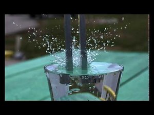 Vibrating tuning fork plunged into water in slow motion