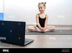 kid girl in a gymnastic leotard practices yoga with a trainer online. Video lesson. Self-isolation during quarantine. Good home concept Stock Photo - Alamy