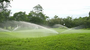 Download Automatic high-pressure water sprinkler at green golf course watering the grass for free