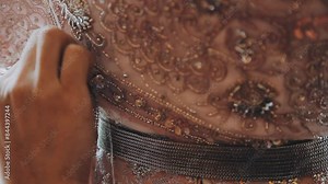 A skilled dressmaker fitting a dress on a mannequin, exhibiting utmost care and detail.