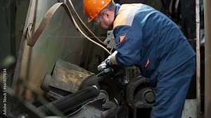 Professional worker grinding metal pipe at the industrial facility. Using grinding equipment for metal pipe process in the workshop. Grinding metal pipe to scrape off the excess steel material.