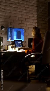 Beautiful stylish female audio engineer and producer working in music recording studio