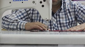 Man sewing a garment on a sewing machine - Free Stock Video
