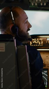 Vertical video: Male airline captain fixing altitude and longitude buttons, using dashboard navigation command and control panel. Flying airplane with aircrew and radar compass, power engine and Stock ビデオ