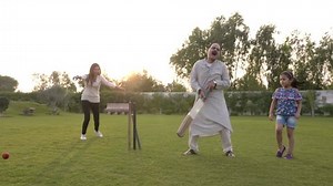A grandfather old elderly fit man batting playing cricket disappoints when gets bowled out as the family celebrates celebrating. A happy family enjoying a holiday together in the open field garden