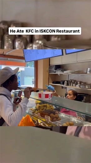 News HUB on Instagram: "A video of a man eating KFC chicken inside an ISKCON restaurant in London The clip shows him offering it to devotees and ignoring staff And he says it was just a prank?"
