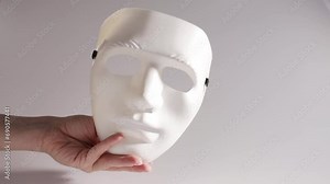White mask in hand, theatrical face, acting courses, elegant theatre accessory, cabaret stage presence Stock Video