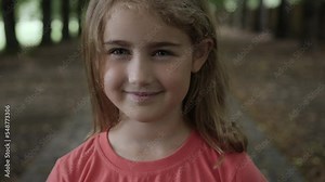 Portrait Smiling Little Girl Looking at Camera. Laughs Happily Child at Outdoors. Inquisitive Little Girl Portrait. Face Funny Contemplative Child. Laughing Cute Pretty Schoolgirl Elementary Student.