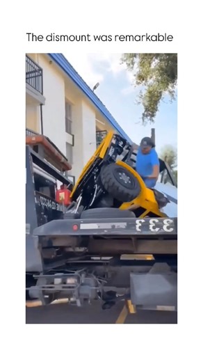 Casm Culture on Instagram: "This video captures a dramatic and failed attempt to unload heavy machinery, resulting in a dangerous equipment tip-over. ​The Subject ​A large flatbed tow truck is parked in an outdoor lot near a multi-story building. On the back of the flatbed, a yellow and black forklift is being prepped for unloading. Several workers, including men in an orange shirt, a blue hoodie, and a grey shirt, are positioned on and around the truck to manage the process. ​The Mechanism ​As 