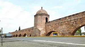 Morelia, Mexico. August 9, 2024: Ancient Morelia Aqueduct, a colonial masterpiece, stands serene amidst whirling traffic, showcasing Mexico's rich history and modern dynamism in harmony.