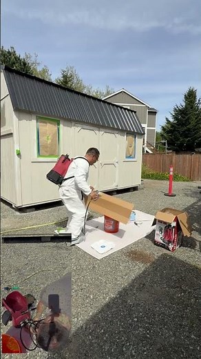 Painting my shed with an airless backpack sprayer.